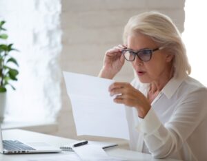 Surprised senior woman looking at paperwork